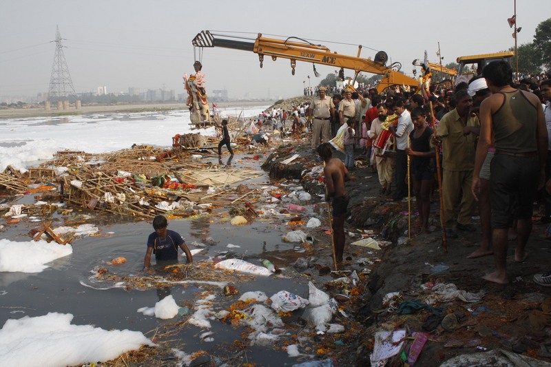Devotees gather on the banks of the polluted River Yamuna to immerse idols of Hindu goddess Durga during the Durga Puja festival. Image by Burhaan Kinu. Copyright Demotix (24/10/12)