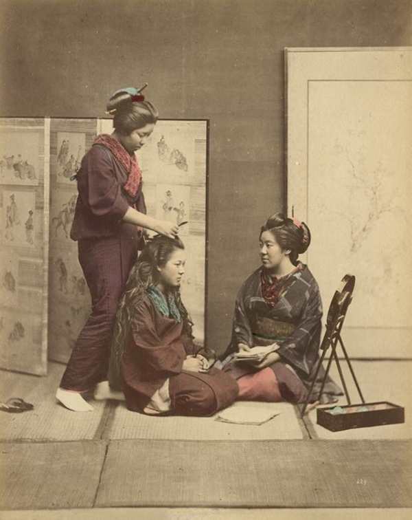 Trois Japonaises ajustant leur coiffure, datant c. 1880. Domaine Public
