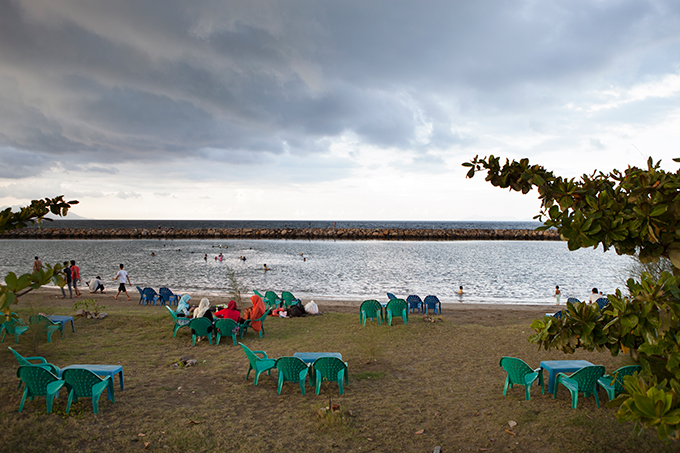 Women sitting by a seawall in Banda Aceh, Indonesia. Photo by Ivan Sigal, 2012.