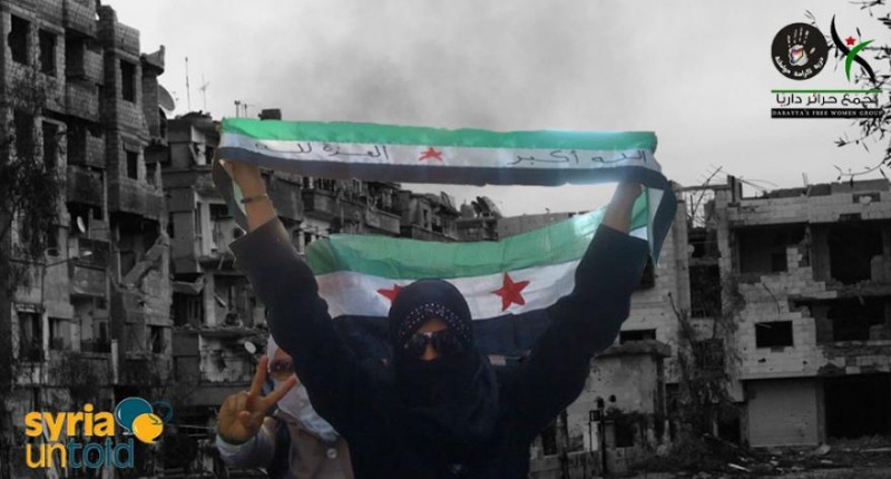 Syrian women raise the Syrian revolution flag. Photo source: Syria Untold