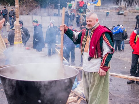 A man minds several caldrons of food being prepared for protesters, making sure the meal doesn't burn. Photo by Clashot user Volye101, used with permission. 