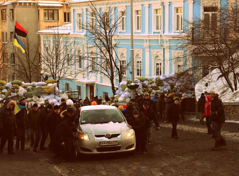 Protesters help the driver by pushing his car up the street. Photo by Olha Harbovska, used with permission.