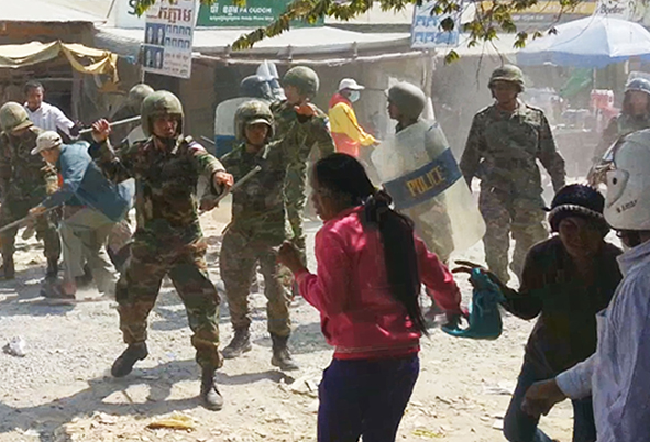 Soldiers threaten a female bystander during a crackdown of the labor protest in Phnom Penh. Photo from Licadho