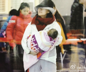 Chai Jing holding a newborn baby at an airport (Picture from Sina Weibo) 