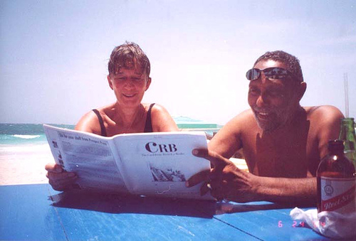 Stuart Hall (R) reading a copy of The Caribbean Review of Books at at Hellshire Beach, Jamaica; June 2004.  Photo by Annie Paul. 