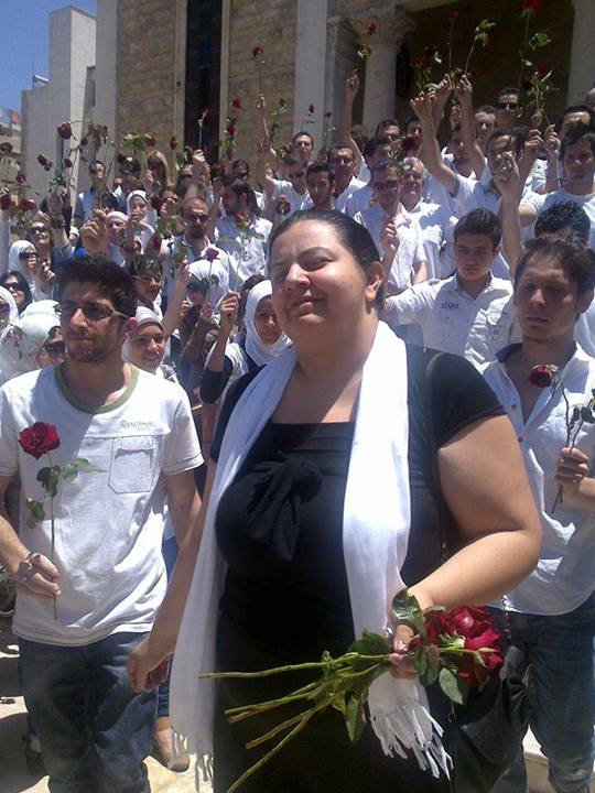 Marcell Shehwaro at the funeral of her mother, who was killed at a Syrian regime forces' checkpoint in June 2012. Fellow activists paid tribute by carrying red roses.