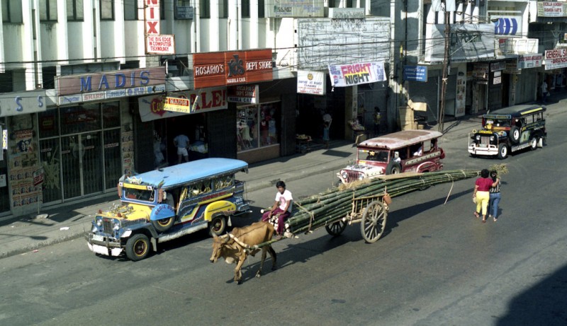 A jeepney beside a bullock with a cart. Flickr photo by 333junction (CC License)
