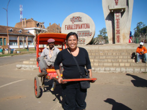 Ariniana poserar med en rickshaw och dess ägare i Antsirabe, Madagaskar (bilden publicerad med hennes tillåtelse) 