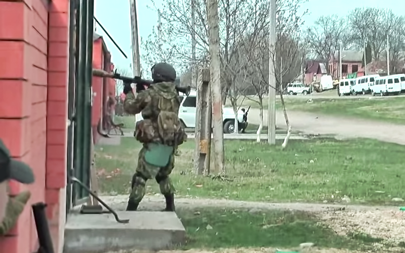 A screenshot from a YouTube video posted from hardingush's account. The special forces soldier is about to fire a grenade launcher during an anti-terrorist operation in the North Caucasus.