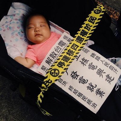 A baby sleeping in the anti-nuke protest on April 27 2014. The yellow banner said 'Stop the 4th nuclear power plant and give the right back to the people.' Photo by Instagram user vincentkensei. CC BY-NC 2.0.