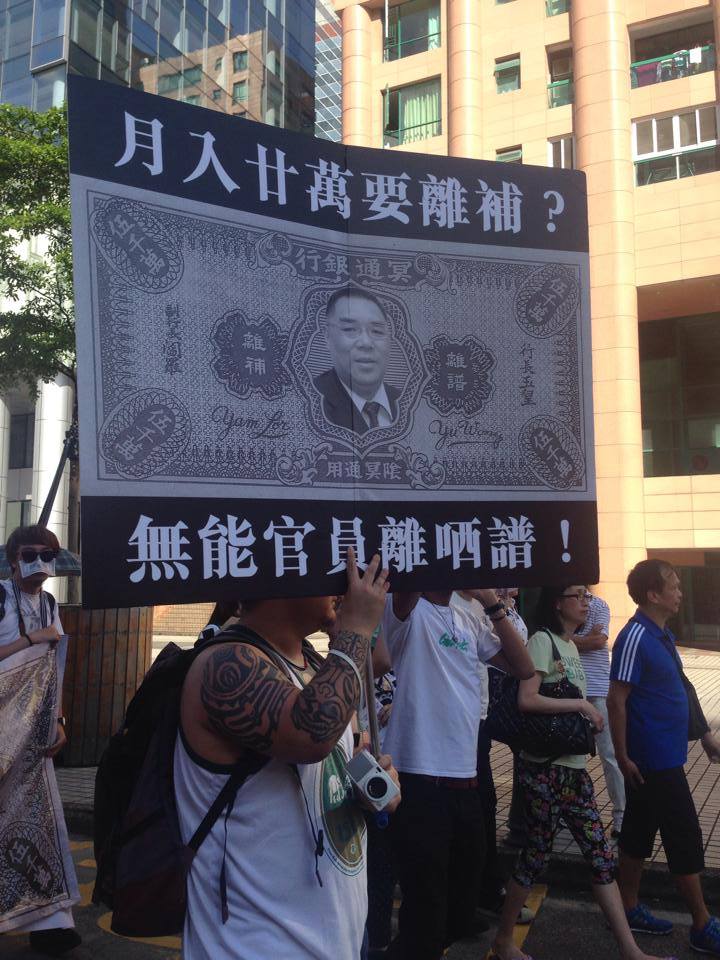  A protest placard showing the Macau Chief Executive's face on a underworld bank note. The slogan on the placard is:  A monthly salary more than 200 thousand dollars [about 25 thousand US dollars] wanted out-going compensation? Impotent officials are out of their mind! Photo from All About Macau Facebook Page