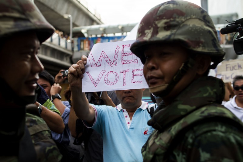 Un manifestante enseña un cartel a favor de la democracia a soldados tailandeses mientras se manifiesta en la zona de Siam contra el golpe de estado (Bangkok, Tailandia) Foto de Biel Calderon, Derechos de autor @Demotix (5/23/2014)