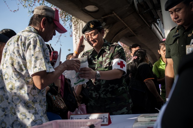 Military doctor hand medicine to a man who attend the reconciliation event at Victory Monument. Photo by Yostorn Triyos, Copyright @Demotix (6/4/2014)