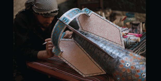 Syrian artist Ali Abu al-Fawz works on a rocket shell in Douma, Damascus. Source: the artist's facebook page