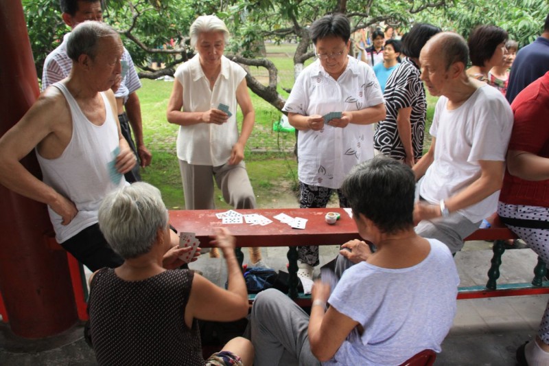 Retired seniors play cards in a park in China. 