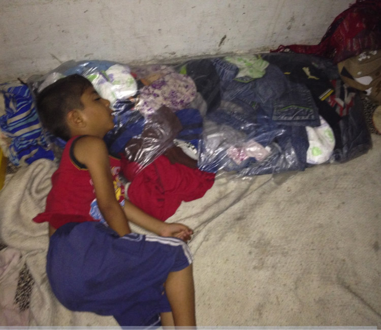 A child sleeping on a make-shift pillow made of a bag of clothes in Heba's room. Photo by author. 