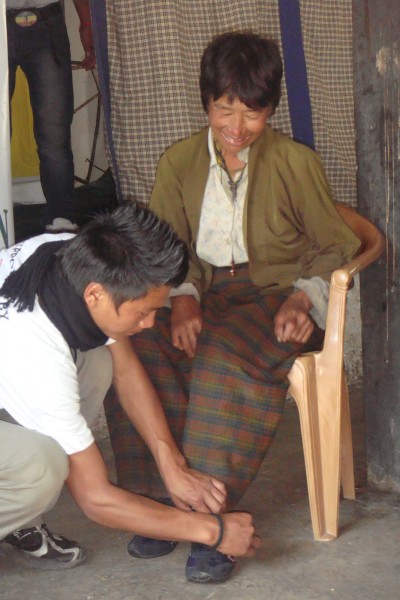 Jen kiom ĝoja estis la sinjorino ricevinte paron da ŝuoj dum transdonado en la distrikto Zhemgang, unu el la plej malriĉaj regionoj de Butano. Bildo de Help Shoe Bhutan. Uzata kun permeso.