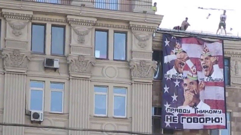 "A banner unveiled across the exterior of the U.S. embassy in Moscow," RuptlyTV, YouTube screen capture.