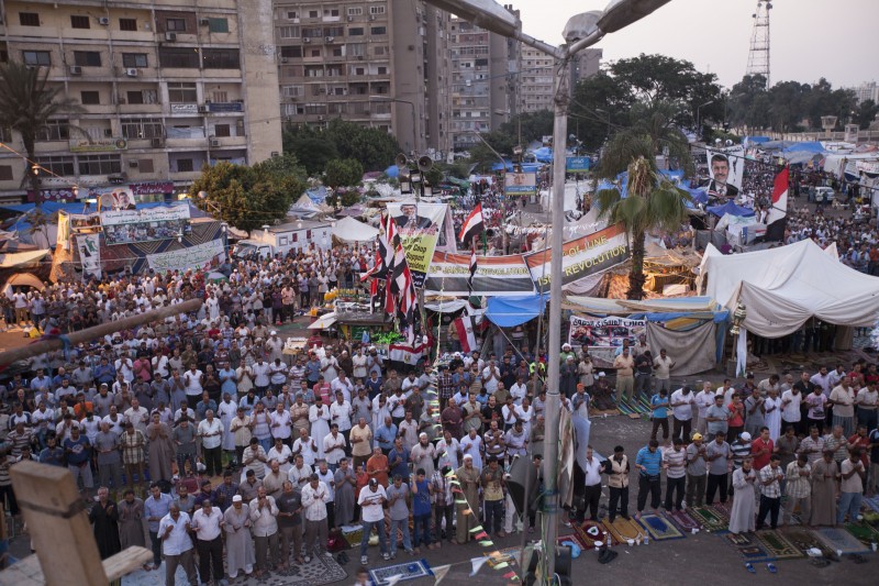Káhira, čtvrť Nasr, 20. července 2013. Stoupenci sesazeného egyptského prezidenta Muhammada Mursího při modlitbě před mešitou Rabaah al-Adawiya, kde protestující rozbili tábor a každodenně demonstrovali. Následující měsíc došlo k brutálnímu zákroku proti tomuto protestu, který za sebou zanechal stovky mrtvých. Autorka fotografie Francesca Volpi. Copyright Demotix.