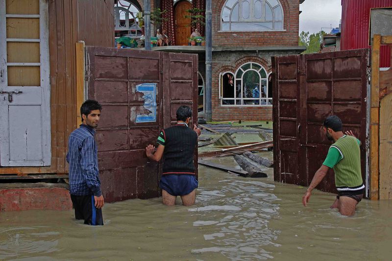 A group of youth try to evacuate goods from a flooded house in Bemina Srinagar, Kashmir. Image by Faisal Khan. Copyright Demotix (5/9/2014)