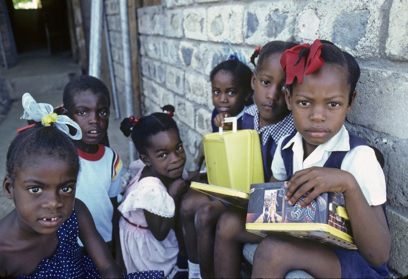 Děti v improvizované učebně provozované místní komunitou pro obyvatele squatů jamajského Kingstonu. Fotografie OSN, použita v rámci licence CC BY-NC-ND 2.0.