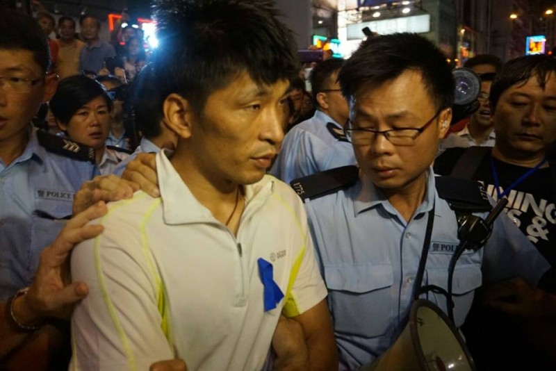 Po zaatakowaniu prodemokratycznych protestujących, awanturnicy zostali odeskortowania do wozów policyjnych. Zdjęcie z inmediahk.net
