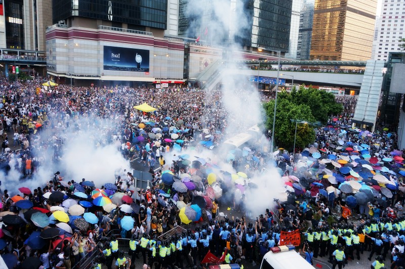 28. září. Protestující v Hongkongu společně vzdorují slznému plynu, kterým na shromáždění zaútočila policie. Autor fotografie P. H. Yang. Copyright Demotix.
