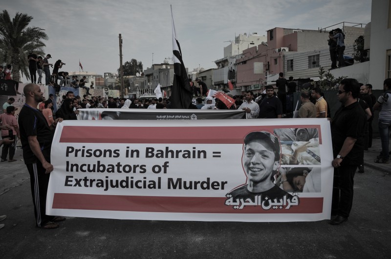 al-Daih, Bahrein. 28 februari 2014 -- Aan de kop van de demonstratie wordt een spandoek meegevoerd met Jafar al-Dirazi's foto. -- Bahreinse veiligheidstroepen schoten traangas- en stungranaten af op demonstranten na de begrafenis van Jafar al-Dirazi die stierf in gevangenschap door foltering en medische verwaarlozing. Copyright: Demotix