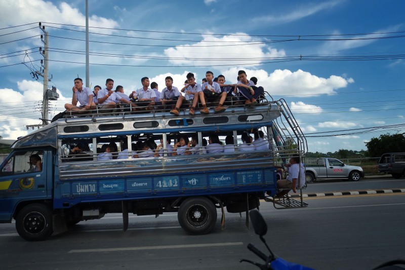 Thajští školáci cestují domů na střeše přeplněného náklaďáku. Autor fotografie Matthew Richards, copyright @Demotix (7/18/2013).