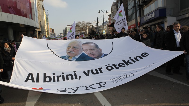 V prosinci 2013 protestovaly tisíce lidí v Istanbulu proti korupci a Erdoğanově vládě. Transparent s tvářemi Fethullaha Gülena a premiéra Erdoğana říká „jeden není o nic lepší než druhý“. Autorkou fotografie je Fulya Atalay, zdroj Demotix.