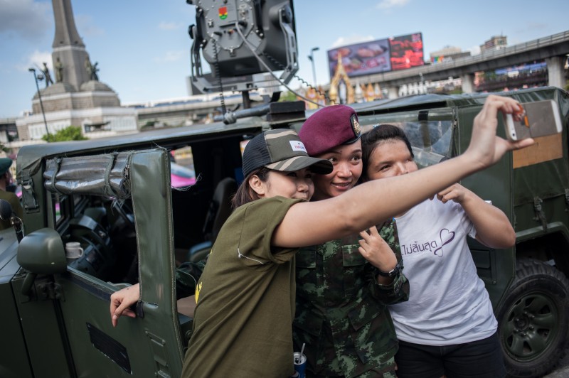 Podporovatelky převratu se fotí s vojákyní u památníku vítězství v Bangkoku. Autor fotografie Yostorn Triyos, Copyright @Demotix (6/8/2014).