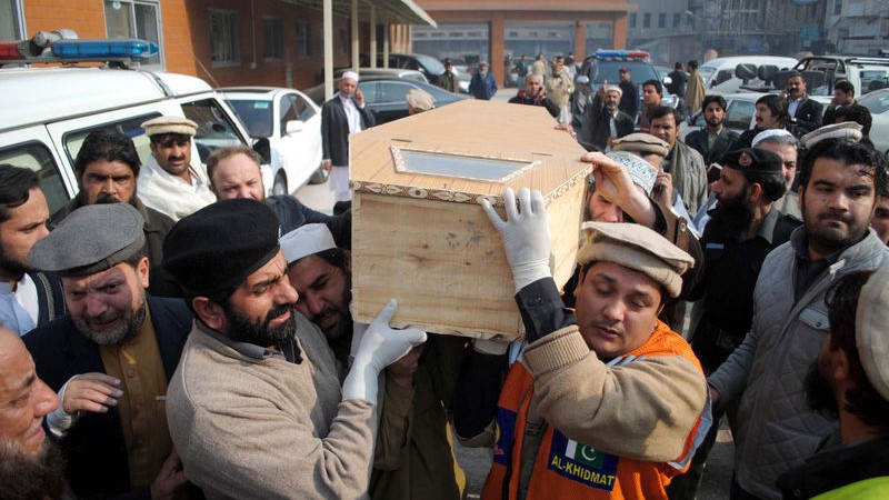 Men carry the casket of a victim of the Taliban shoot-out in a military-run school in Peshawar, Pakistan. Image by ppiimages. Copyright Demotix (16/12/2014)