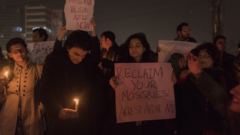 Protestující drží transparent proti duchovnímu Abdulu Azízovi. Autorem fotografie je Saad Sarfraz Sheikh, copyright Demotix (22/12/2014).