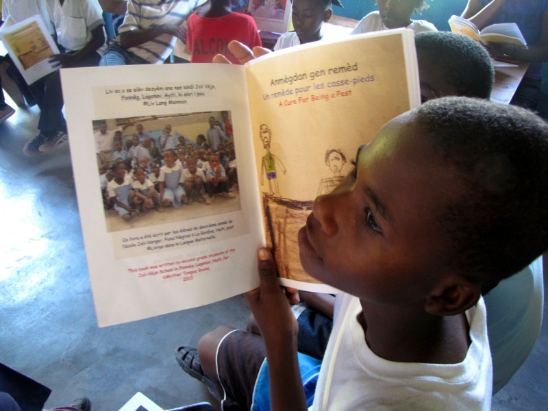 Fifth-grader Kervenson Succès reads a student-authored book, "A Cure for Being a Pest," printed in Creole, French and English. Credit: Amy Bracken (Used with permission)