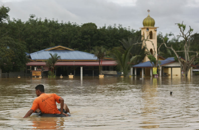 A man sits on a float tires in a flood affected area in Temerloh, 150 km (93 miles) outside of Kuala Lumpur, December 27, 2014. Photo by SAMMY FOO. Copyright Demotix