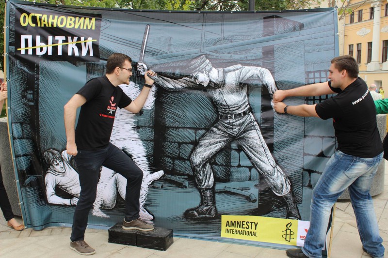 "Committee Against Torture" activists poses with an Amnesty International banner. June 27, 2014. Bashkortostan, Russia. Pytkam.net.