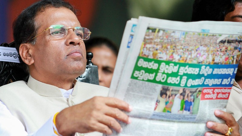 Sri Lanka's main opposition presidential candidate Maithripala Sirisena reads a newspaper during a campaign rally for the upcoming presidential elections in Colombo. Image by Chamila Karunarathne. Copyright Demotix (31/12/2014)