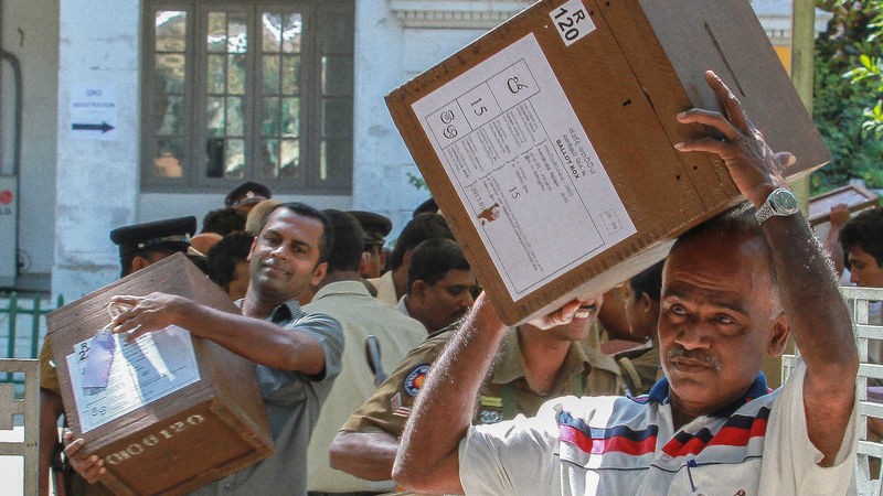 Sri Lankan election commission workers carry ballot boxes while escorted by police on the eve of presidential elections in Colombo. Image by Chamila KarunaRathne. Copyright Demotix (7/1/2015)