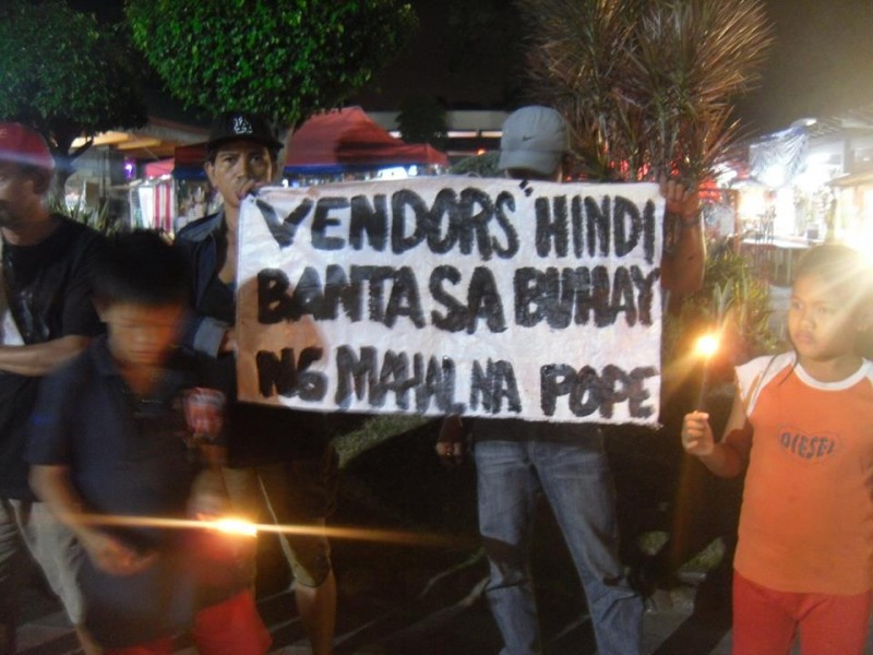 Prodejci z parku Luneta s plakátem: „Pouliční prodejci nejsou hrozbou pro život našeho drahého papeže.“ Fotografie z facebookové stránky Tanggol Kabuhayan (Braňte práci).
