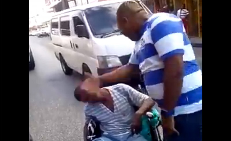 A screenshot of the video that has been circulating on social media showing a plain-clothes policeman in Trinidad and Tobago slapping a man in a wheelchair. 