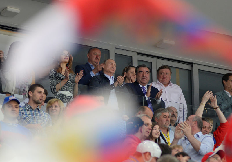 Tádžický prezident Emómalí-ji Rahmón stojí mezi Vladimirem Putinem a Alexandrem Lukašenkem při vítězství Ruska na Mistrovství světa v ledním hokeji. Autor fotografie Ivan Uralsky, Demotix ID 4848568.