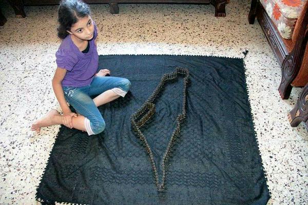 A Palestinian girls draws the map of Palestine using Israeli bullets. Photograph shared by @Palestinianism on Twitter 