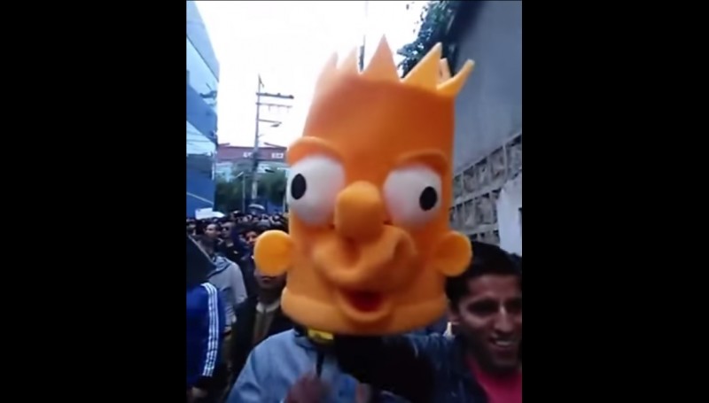 A protester holds up a Bart Simpson head during a rally calling for Unitel to bring back "The Simpsons". Screenshot from YouTube.