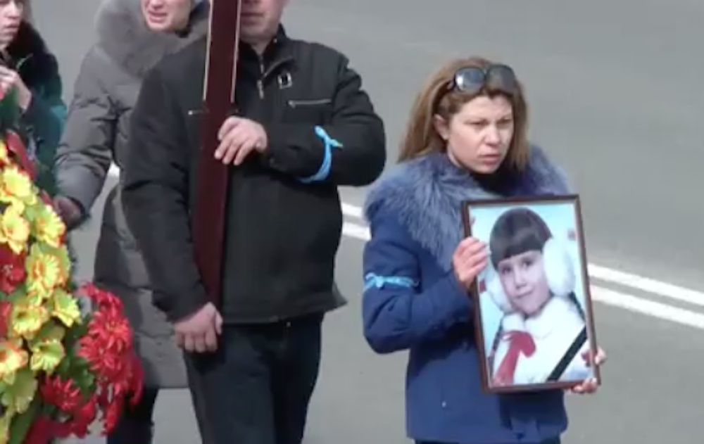 Family and mourners carried the slain child, Polina, through the streets of Konstantinovka in a funeral procession before laying her to rest. March 18, 2015. YouTube screen capture. RuptlyTV.