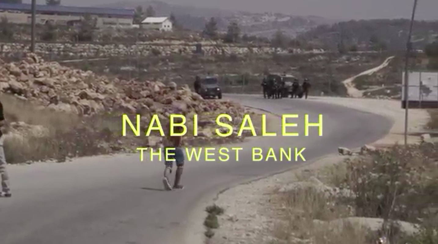 Screenshot from 'Discarding Gaza' showing a Palestinian stone-thrower facing Israeli soldiers