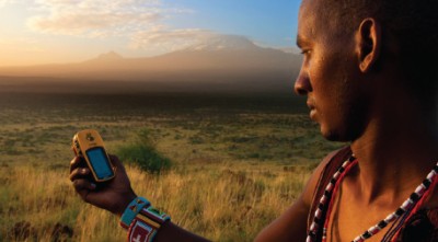 Lion Guardian Ng’ida takes a GPS point in front of Mt. Kilimanjaro. GPS data help Lion Guardians track animals and keep livestock out of harm’s way. Photo by Philip Briggs.