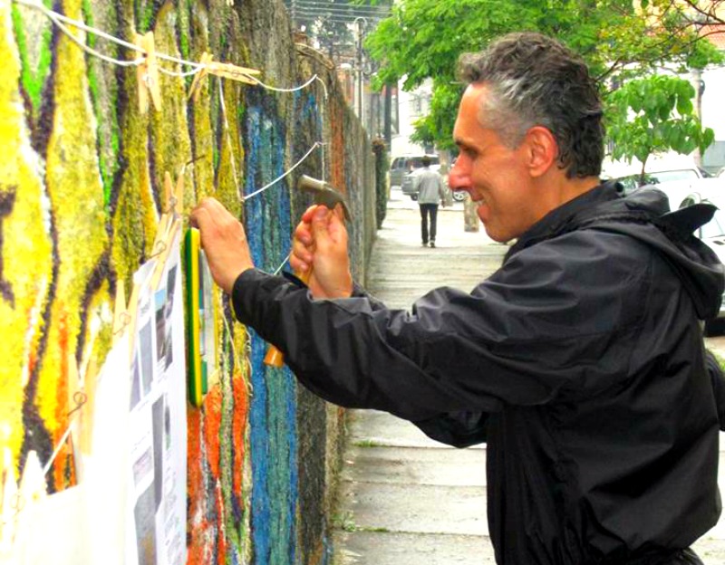 Ricardo Fraga hanging the pictures people drawn at the wall in Vila Mariana. Photo: ARTICLE 19/Facebook