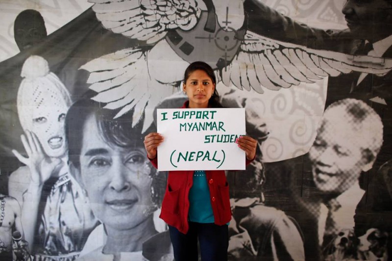 A young person from Nepal holds a placard expressing support to Myanmar student protesters
