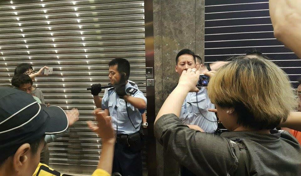 Varios ciudadanos supervisan con sus cámaras el uso de la fuerza por parte de la policía. Foto de  Gundam Lam para inmediahk.net, utilizada con autorización.