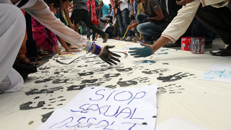 ベンガル正月祭にダッカ大学内で起きた性暴力事件に抗議するため、学生たちが大学周辺に集まり、黒い手形を押した垂れ幕を作成する様子。写真：Sk・ハサン・アリー 著作権：Demotix（2015年4月20日） Copyright Demotix (20/4/2015)